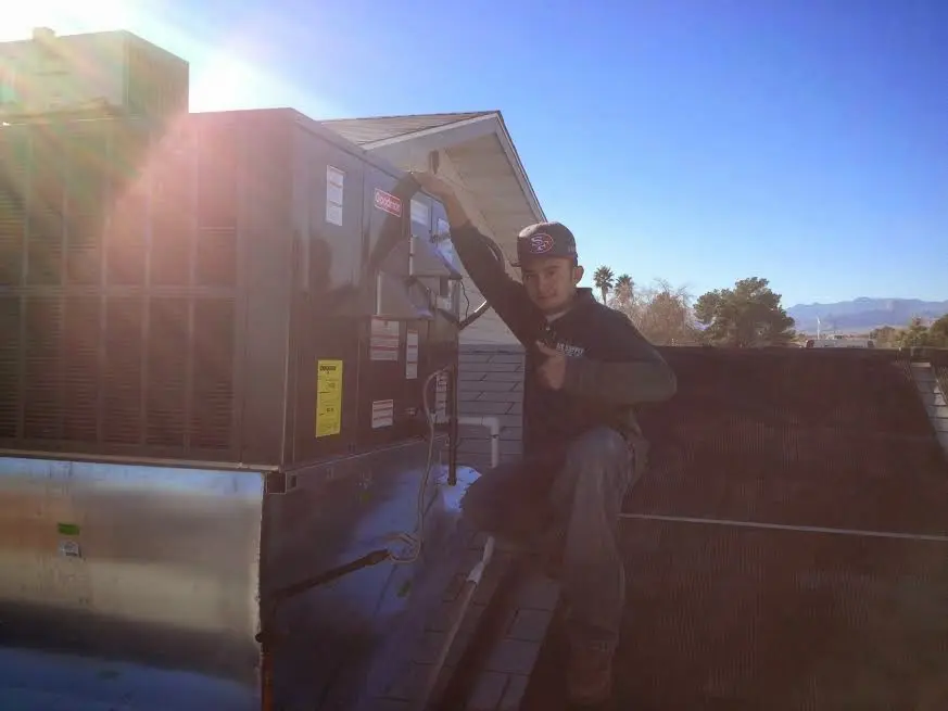 HVAC technician performing Air Duct Repair on a rooftop unit in Joshua